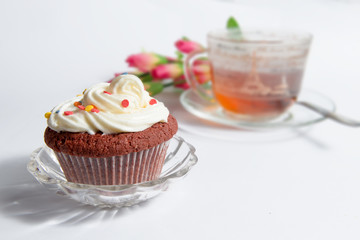 Sweet cake with cup of tea and flowers