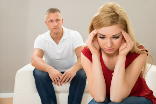 Man On Sofa Looking At Stressed Woman