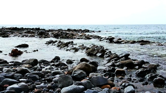 Wild stone shore or coast with waves of ocean or sea