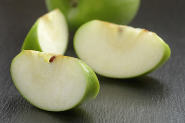 green sour apple on slate board sliced