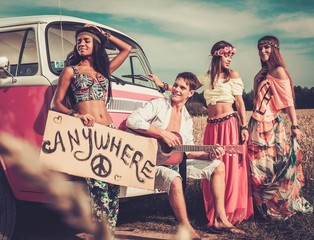 Multinational hippie hitchhikers on a road