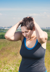 Fitness beautiful plus size woman with pain in her head