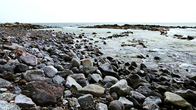 Wild stone shore or coast with waves of ocean or sea