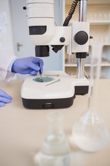 Scientist examining plants with microscope