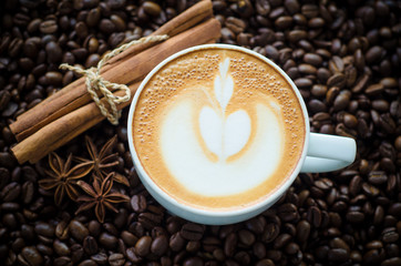 cup of coffee with latte art on coffee bean background