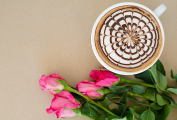 A cup of coffee with latte art and rose on brown paper backgroun