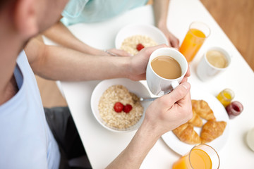 Obraz na płótnie Canvas close up of couple having breakfast at home