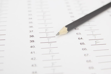 Standardized test form with answers bubbled in and a pencil, foc