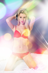 Obraz premium Blonde beauty with red lingerie and headphones in the bed