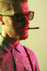 Portrait of handsome casual stylish young man smoking cigarette