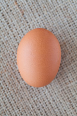 Healthy food brown chicken egg on brown fabric background