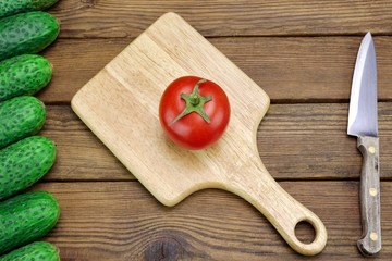 Tomato, Cucumbers And Kitchen Knife On The Rough Wood Background
