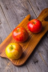 Fresh apples on wooden cutting board