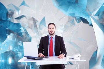 Composite image of unsmiling businessman sitting at desk