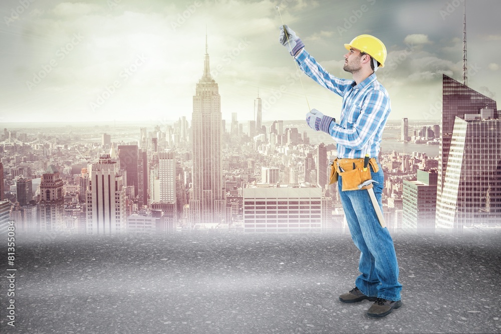 Poster Composite image of construction worker using measure tape