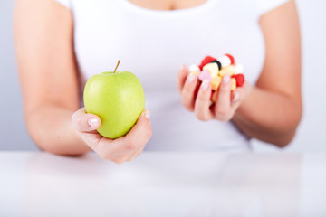 Woman holding apple and candies