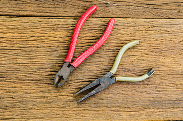 Old rust pliers and pincer on wooden table