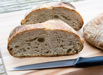 Round french boule bread cut in half with knife
