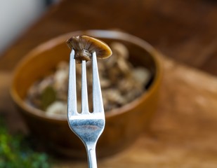 Fototapeta premium Marinated honey fungus in brown bowl on wooden table.