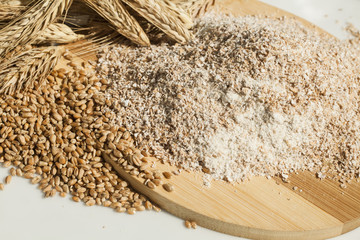 wheat flour of a rough grinding. Grain and spikelets on  table