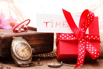 Red gift box tied red ribbon and text "Time"
