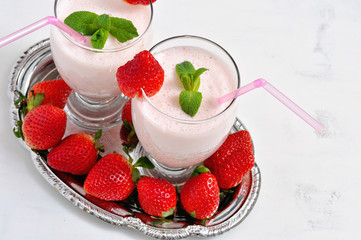 Milk shake with strawberries on white background