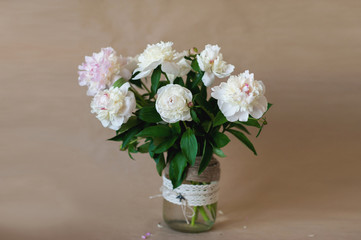 Pink and white bouquet of peonies in a glass vase decorated 