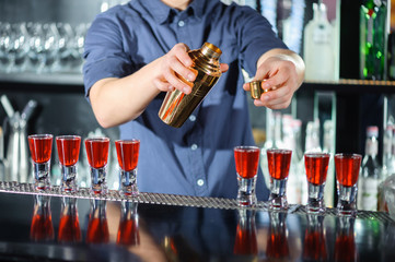 Barman makes shots in a bar