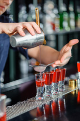 Barman makes shots in a bar