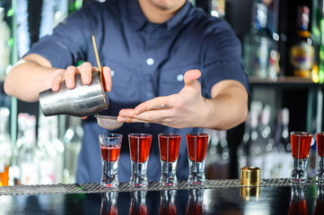 Barman makes shots in a bar