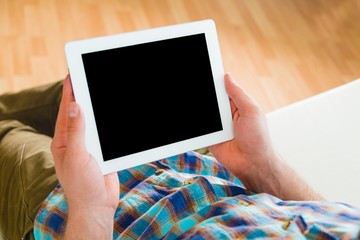 Tablet. Closeup of digital tablet held by man relaxing at home