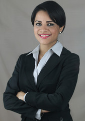 Business latin woman smiling isolated on a gray background