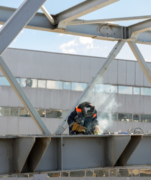 welder welds the steel bridge construction