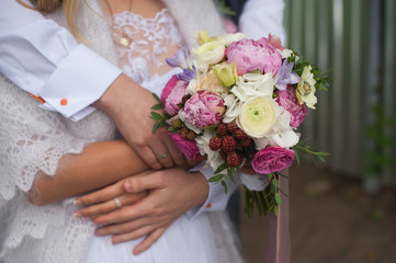 Obraz na płótnie Canvas Beautiful wedding bouquet in hands of the bride and groom