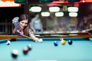 Young beautiful young lady aiming to take the snooker shot - obrazy, fototapety, plakaty
