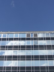 Glasfassade eines modernen Geschäftshaus vor blauem Himmel im Sonnenschein an der Konstablerwache in der Innenstadt von Frankfurt am Main in Hessen
