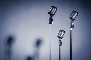 Three old fashioned microphones with space for text