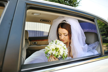 beautiful young bride at the limousine