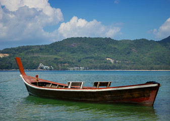 Fototapeta na wymiar Thai wooden boat on a calm sea bay
