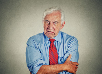 Angry grumpy pissed off senior mature man gray background 
