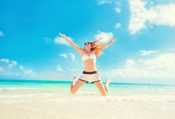 Happy Woman Jumping In The Air having fun On Tropical Beach