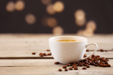 Cup of coffee on table on brown background
