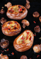 Baked potatoes with mushrooms and spices on pan close up