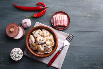 Fried dumplings with onion and bacon in frying pan,