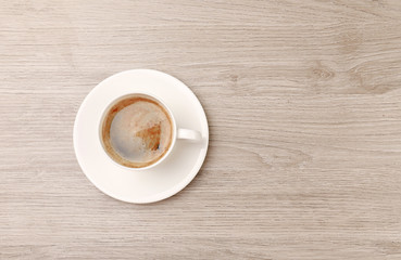 Cup of coffee on wooden table, top view