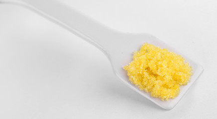 Laboratory spatula with granules isolated on white