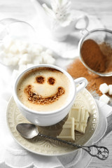 Cup of latte coffee art on wooden table, on light background
