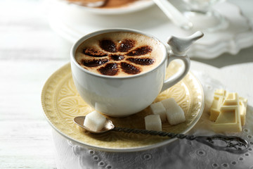 Cup of latte coffee art on wooden table, on light background