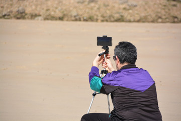 hombre fotografiando en la playa