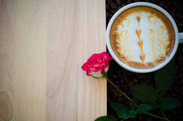 a cup of latte art on wooden and coffee bean background